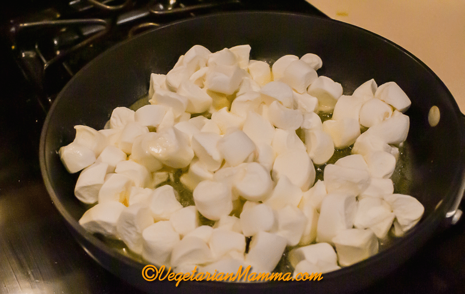 In a large sauce pan, melt the butter and add marshmallows. Stir until well combined and melted.