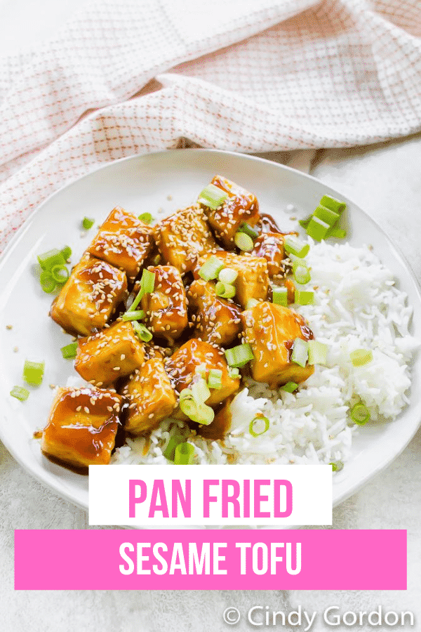 Sesame Tofu is the easiest Asian-inspired vegetarian dish ever! Crispy pan-fried tofu is covered in a soy, honey, and sweet Thai chili sauce and garnished with sesame seeds. #sesametofu #tofu