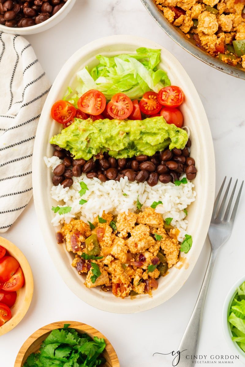 Sofritas in a bowl with lettuce, tomatoes and guac