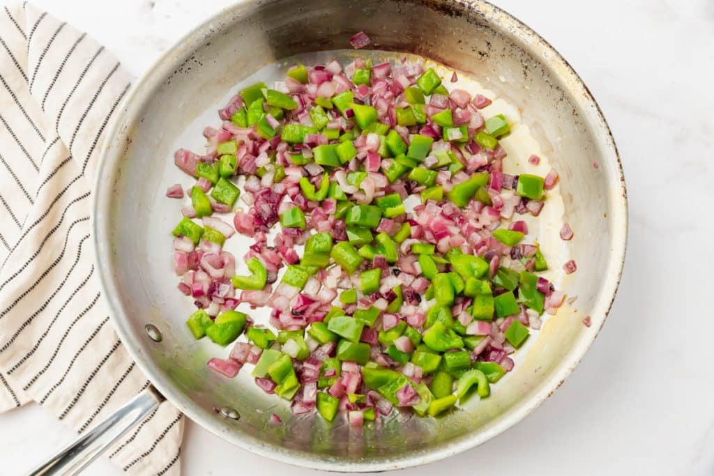 metal skillet with onions and pepers