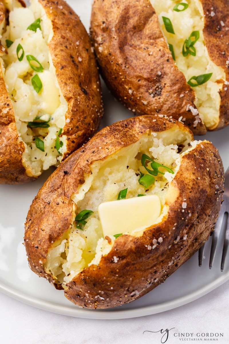 brown baked potato with butter and parlsey
