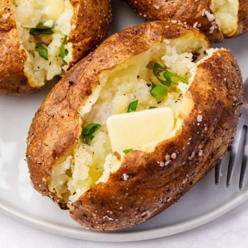 feature image of open brown baked potato with butter and parlsey