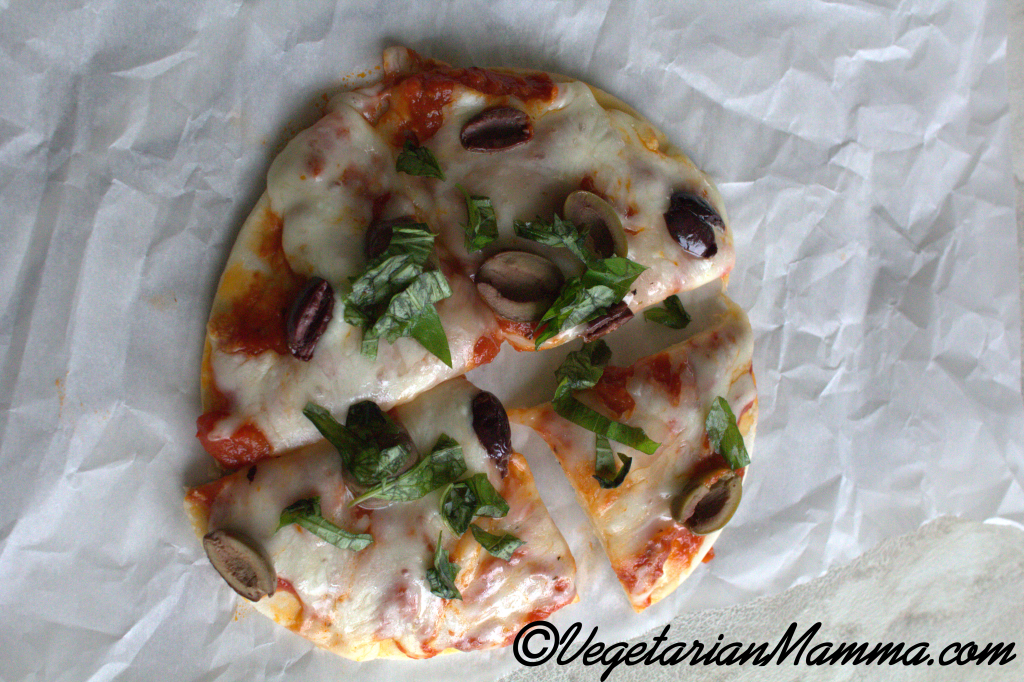 air fryer pizza cut into four pieces - the base is a pita bread.