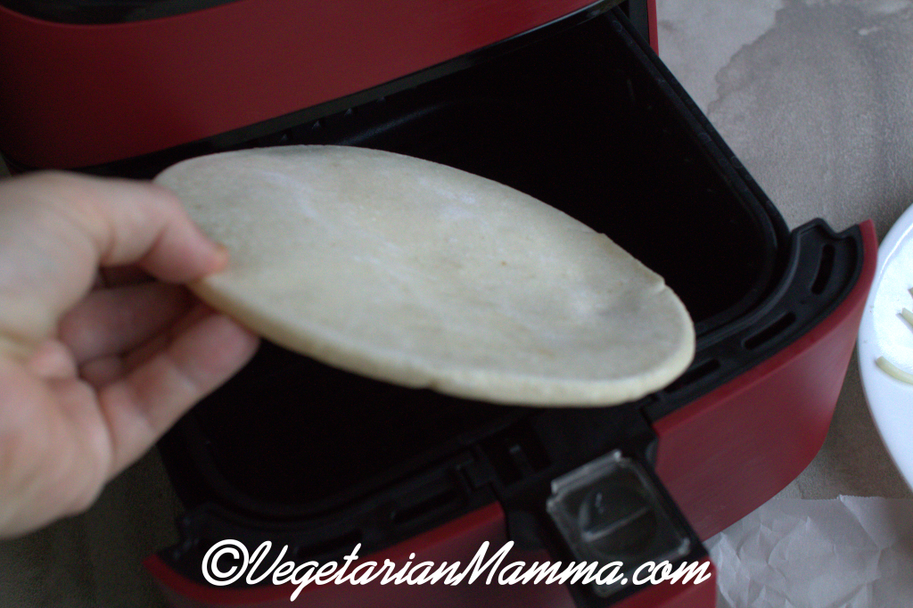 slice of pita going into the air fryer