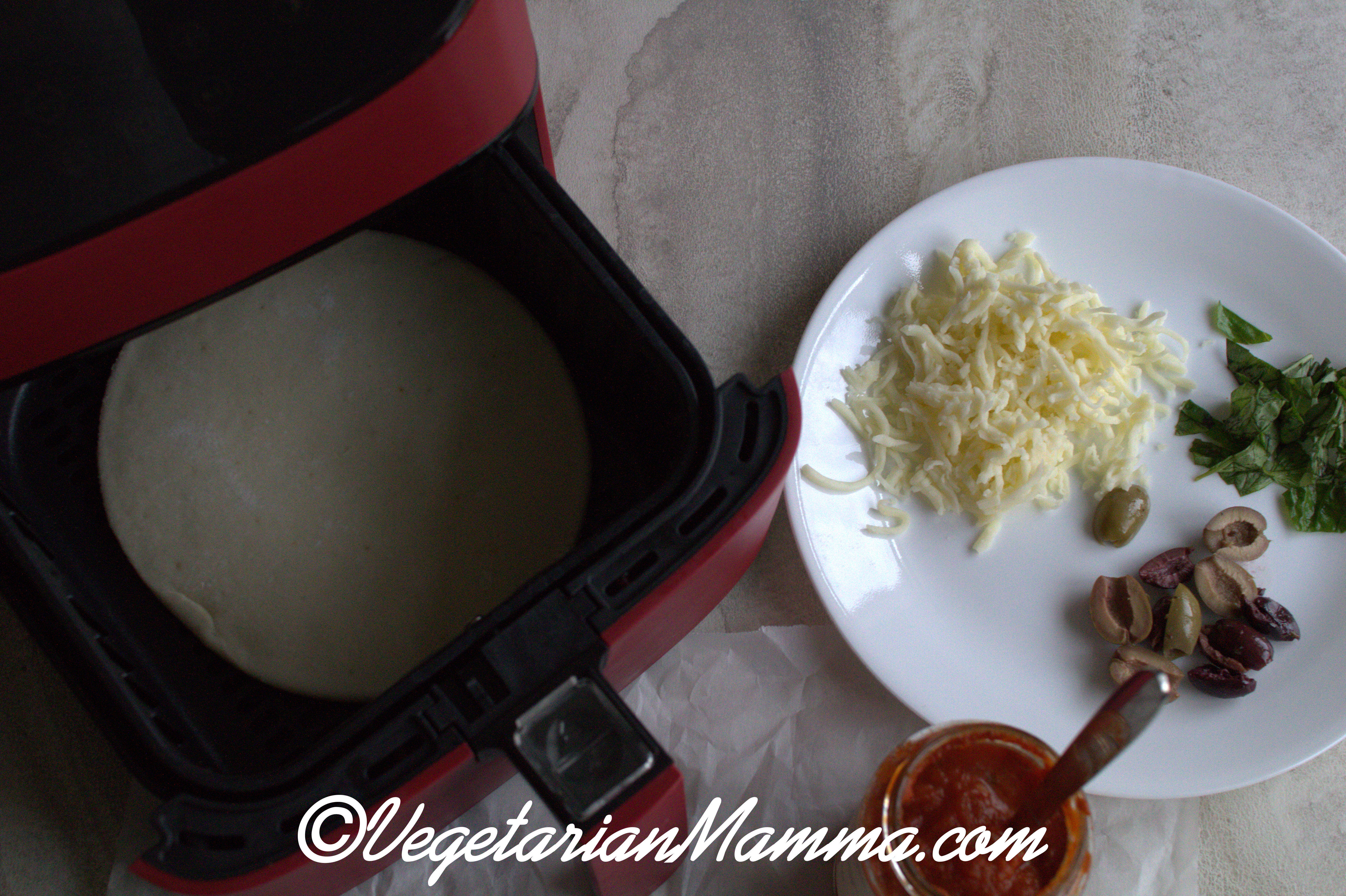 Overhead shot of pizza ingredients and air fryer