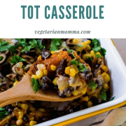 A white pan of Mexican tator tot casserole with a spoon full of the casserole.