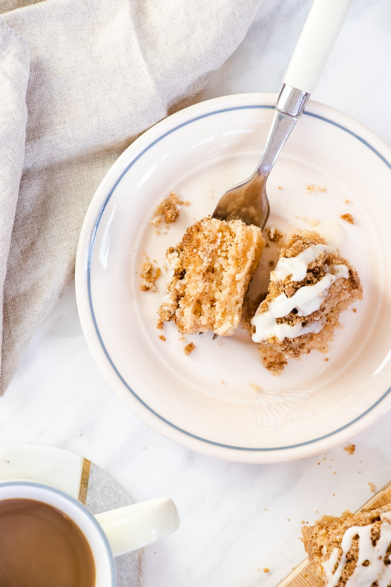 a bite of cinnamon coffee cake on a fork on a white and blue plate