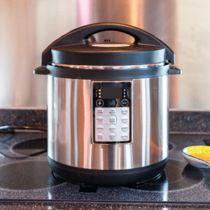 black and silver pressure cooker on black counter