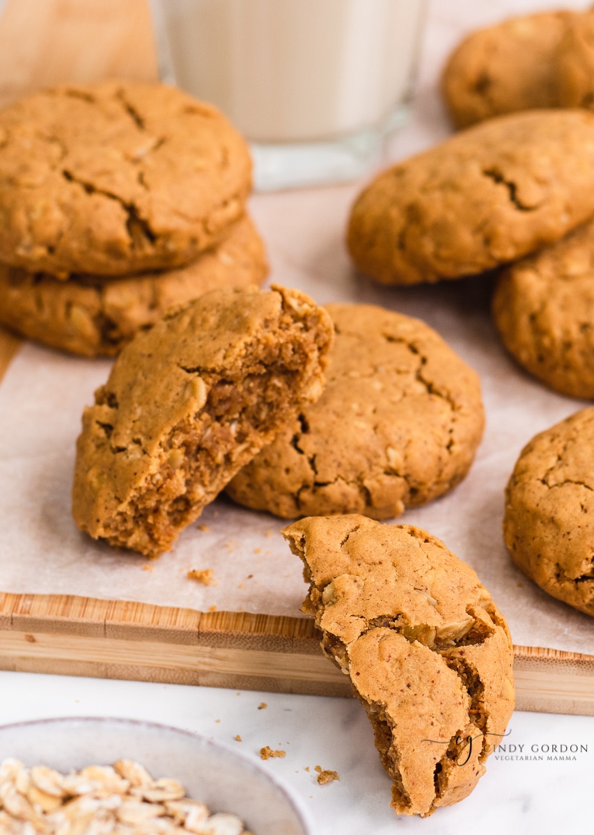 A gluten-free peanut butter cookie split in half next to more whole cookies