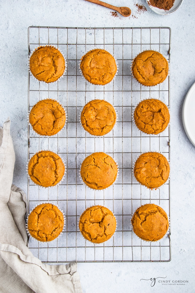 Overhead shot of a dozen pumpkin muffins on a wire rack