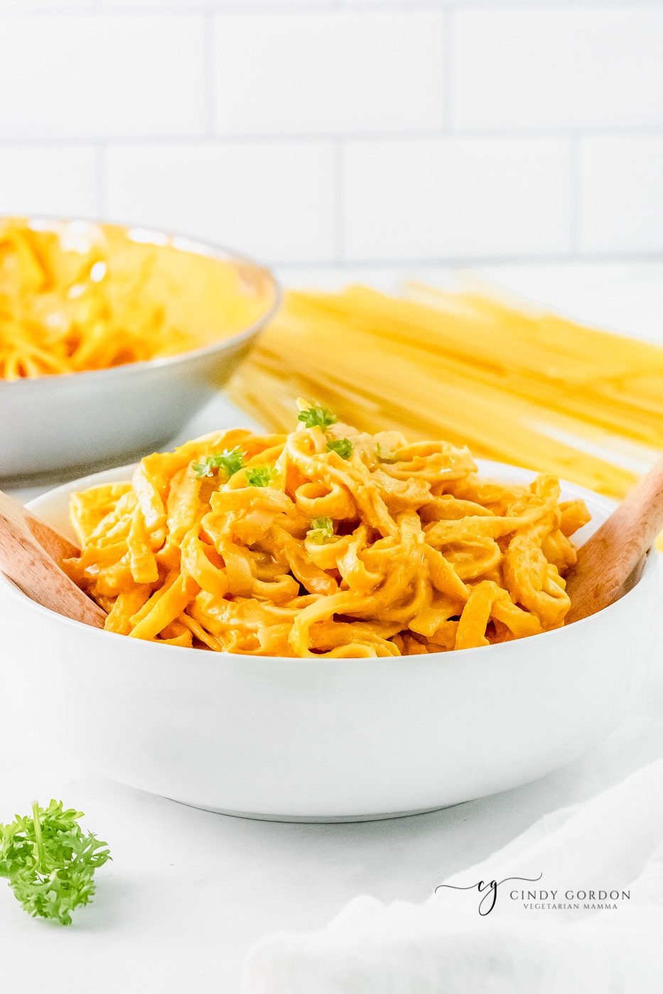 a large serving bowl filled with pumpkin fettuccini pasta. 