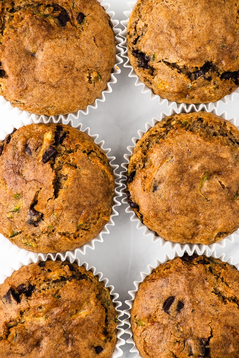 Close-up overhead shot of zucchini chocolate chip muffins in white cupcake liners