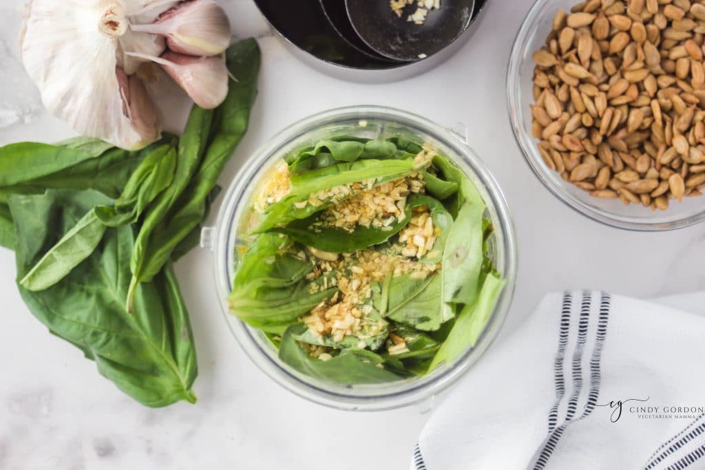 overhead shot of brown crumbles on top of basil in a clear cup