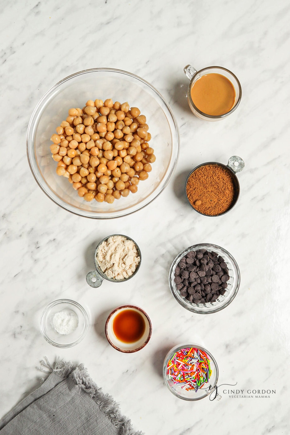 Bowls of chickpeas, cinnamon, coconut flour, coconut sugar, chocolate chips, vanilla, and sprinkles