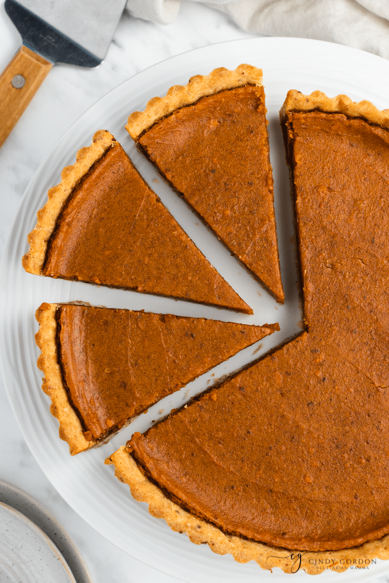 Overhead shot of a whole sweet potato pie with 3 cut slices