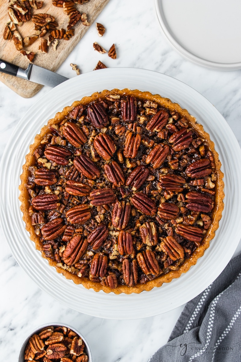 A whole pecan pie on a round white plate