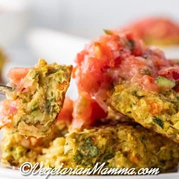 A stack of fritters on a white plate topped with salsa.