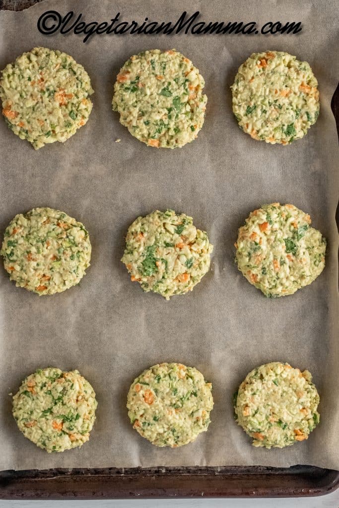 Make the fritters by rolling 1/4 cup of zucchini mixture into a ball. Flatten ball with your hand on baking sheet covered in parchment paper.