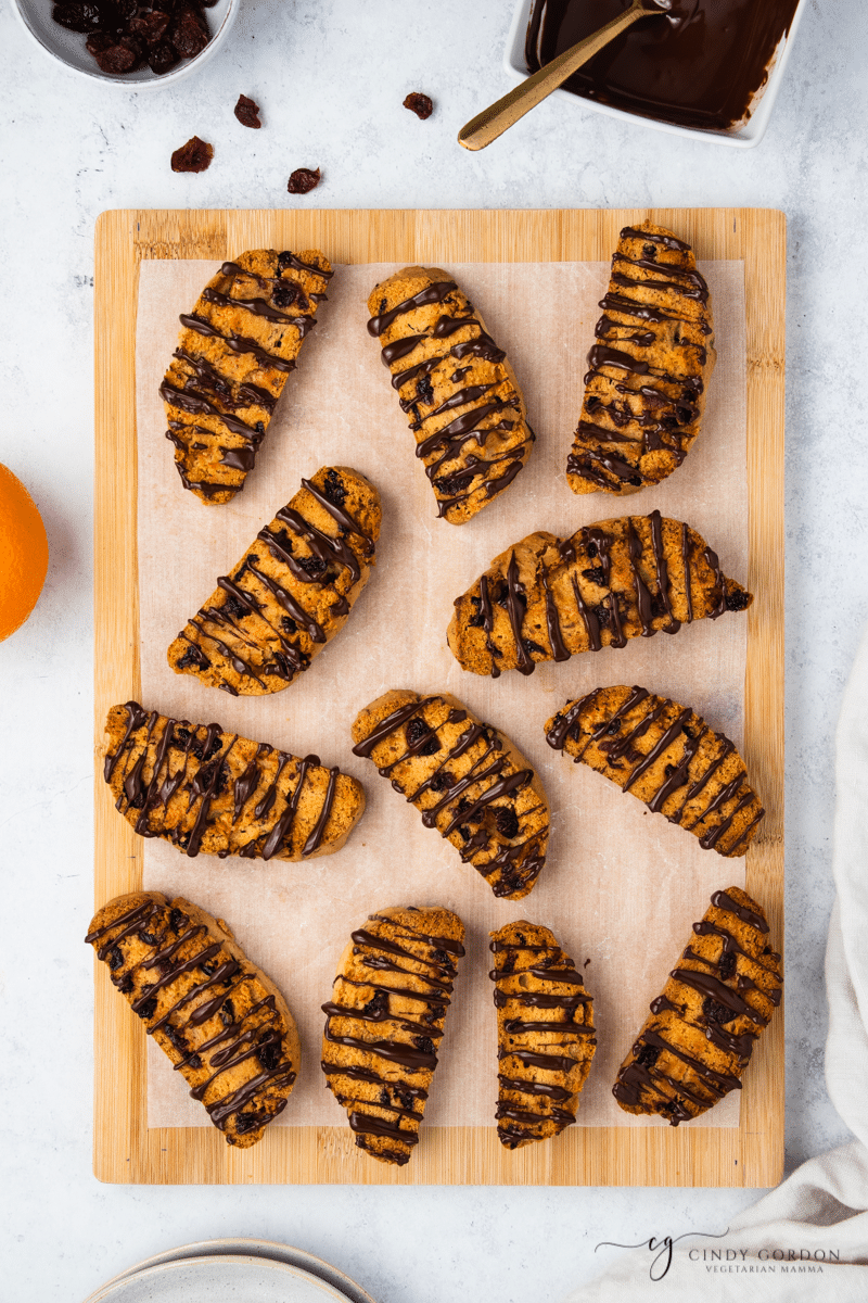 12 vegan chocolate biscotti on parchment paper on a cutting board