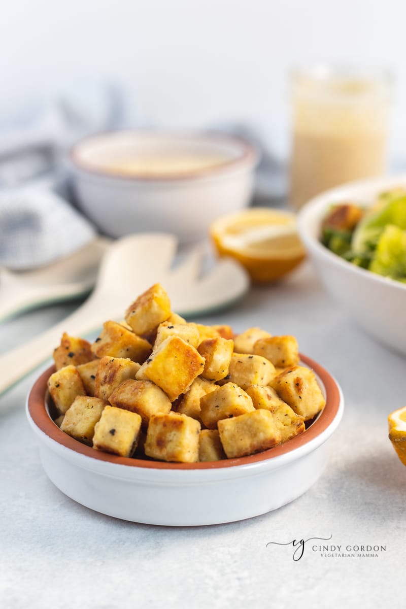 A small white bowl of vegan croutons