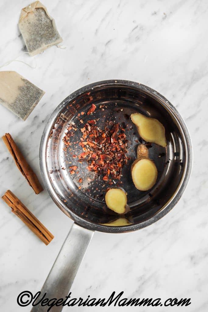 First crush the cardamom pods, cloves, star anise, peppercorns. Place the crushed spices in a small pot with 2 cups of water, ginger, cinnamon sticks and, black tea.