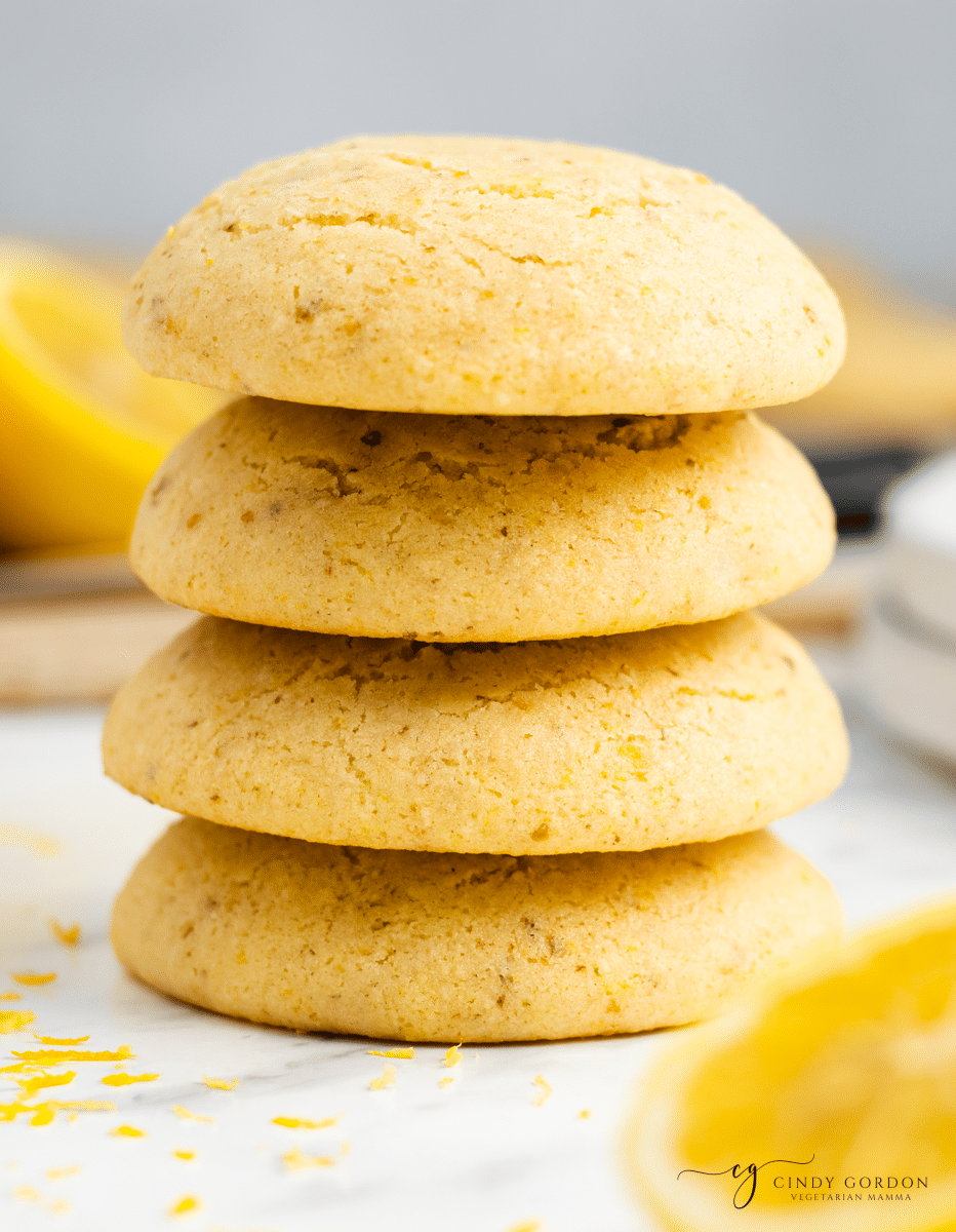 4 stacked yellow cookies on white background with yellow lemon zest