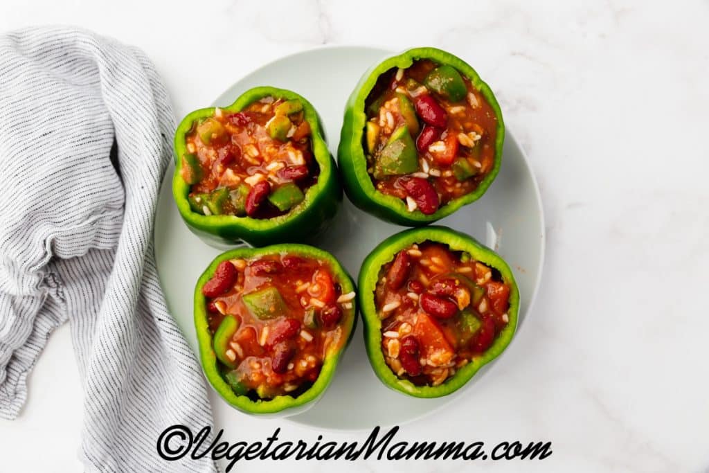 four green peppers stuffed with beans, sauce, and veggies.