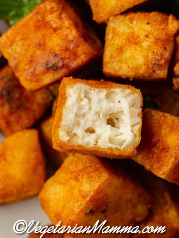 upclose shot of air fryer tofu one tofu with bite out and can see white