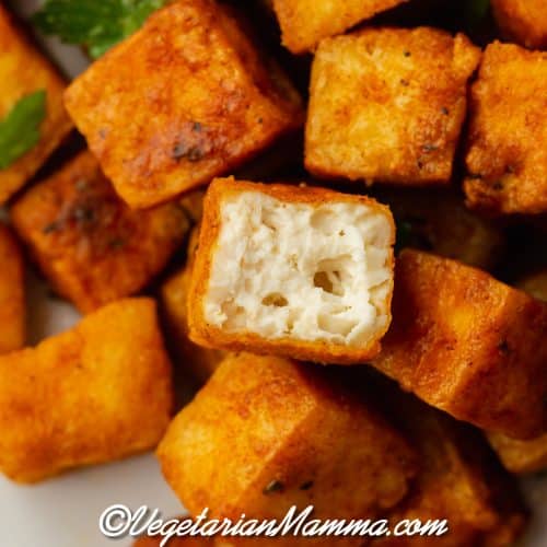 upclose shot of air fryer tofu one tofu with bite out and can see white