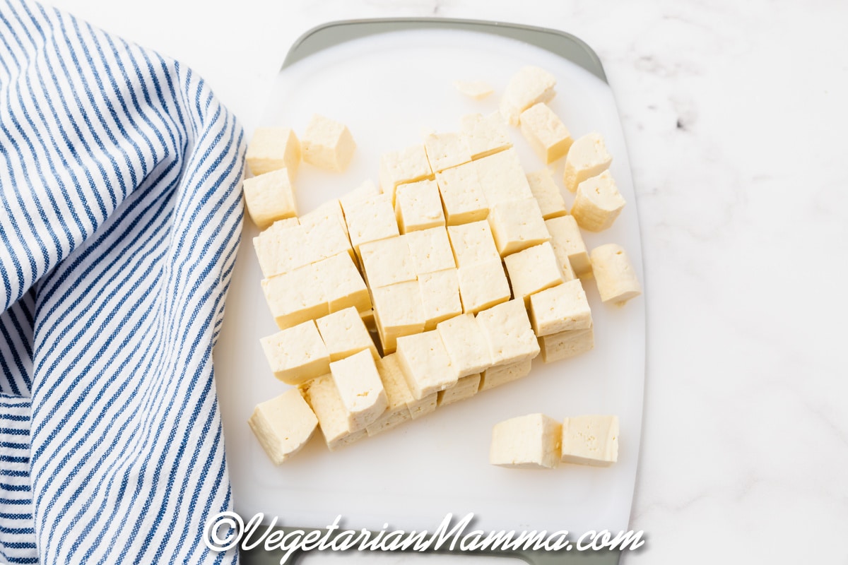 A block of white tofu that has been cubed.