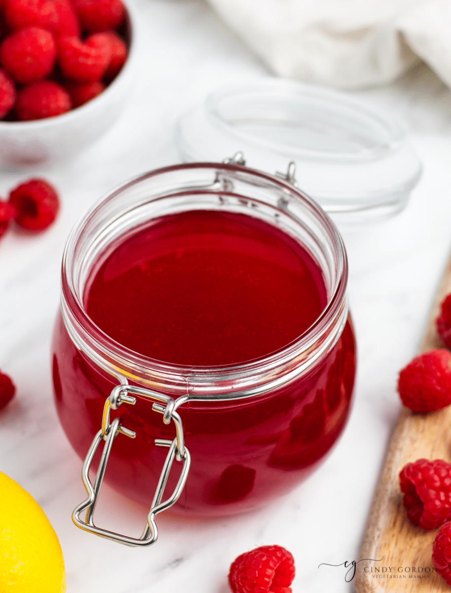 a rounded bail jar full of red raspberry simple syrup