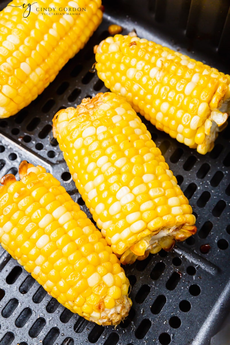 air fryer corn on the cob in a black air fryer basket