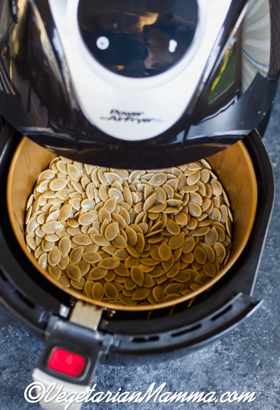 Air Fryer Pumpkin Seeds in the air fryer with the basket open.