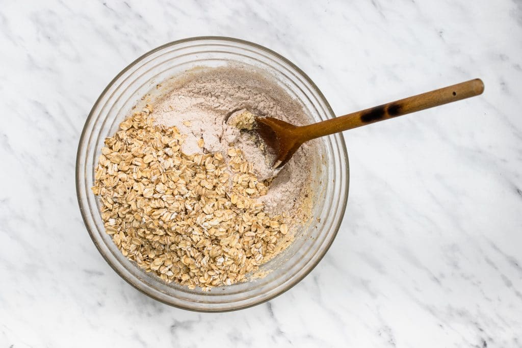 bowl full of flour and oats with wooden spoon