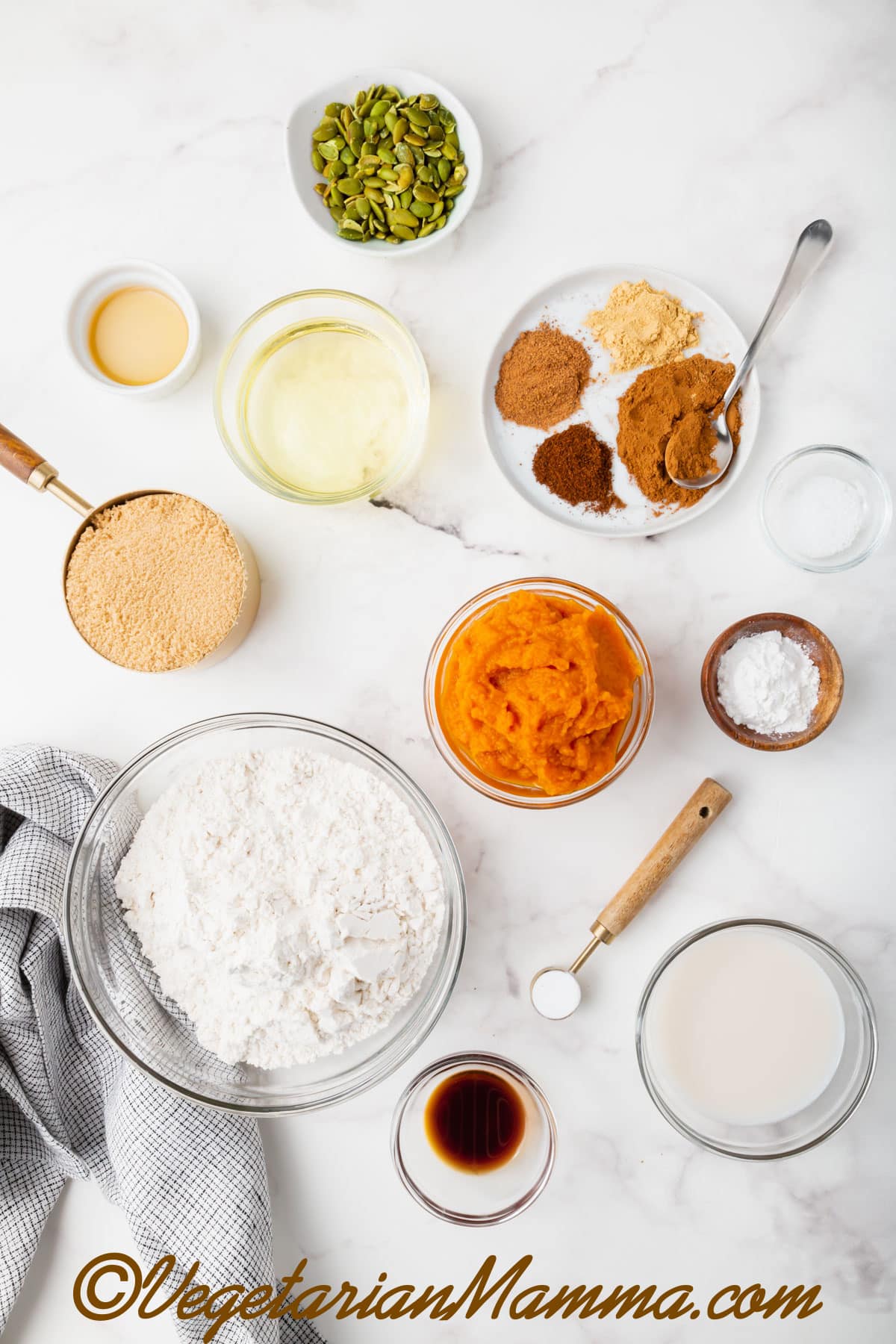 Bowls of flour, pumpkin puree, pumpkin pie spices, baking powder, baking soda, brown sugar, and vegetable oil