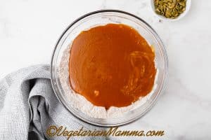 In a medium bowl, add in the brown sugar, pumpkin puree, vegetable oil, unsweetened almond milk, apple cider vinegar, and vanilla extract. Whisk until combined.