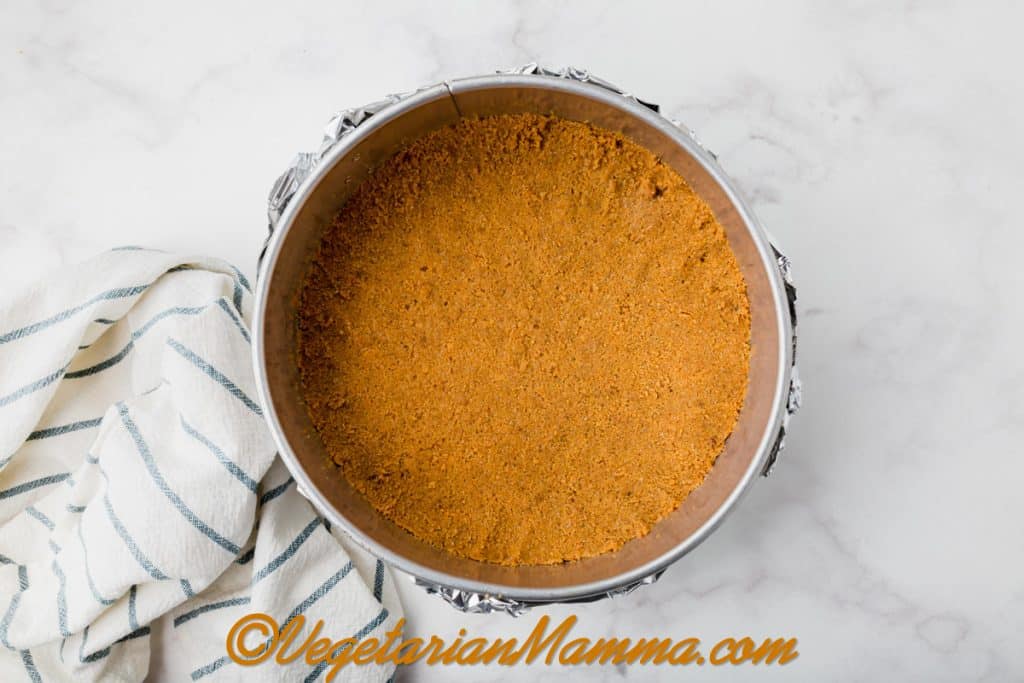 Pour the graham cracker crust mixture into the springform pan and press to an even thickness on the bottom of the pan.