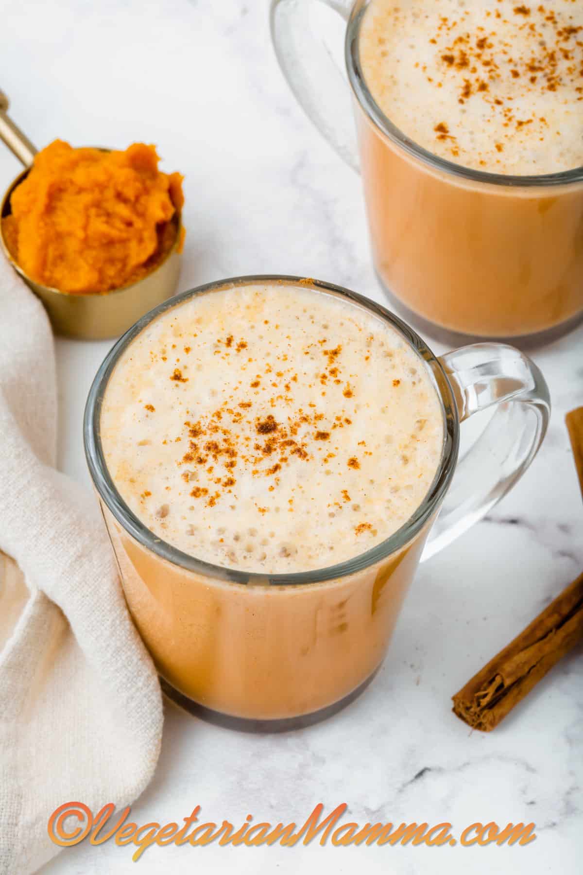 Overhead shot of a pumpkin spiced latte sprinkled with more pumpkin pie spice