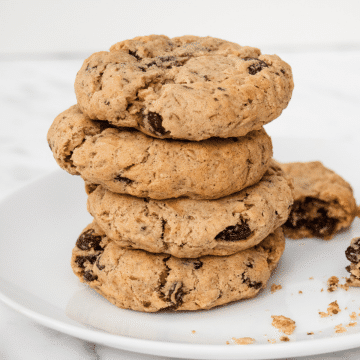 vegan oatmeal raisin cookies - brown fluffy cookies with dark brown raisins cookies are stacked