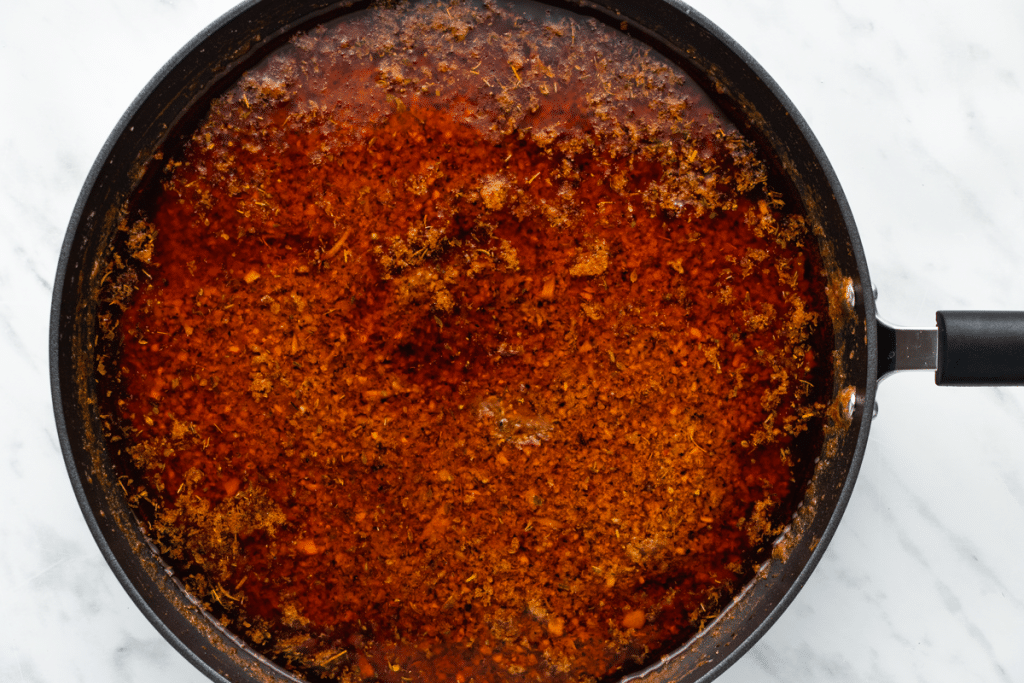 red color liquid in a black sauce pan