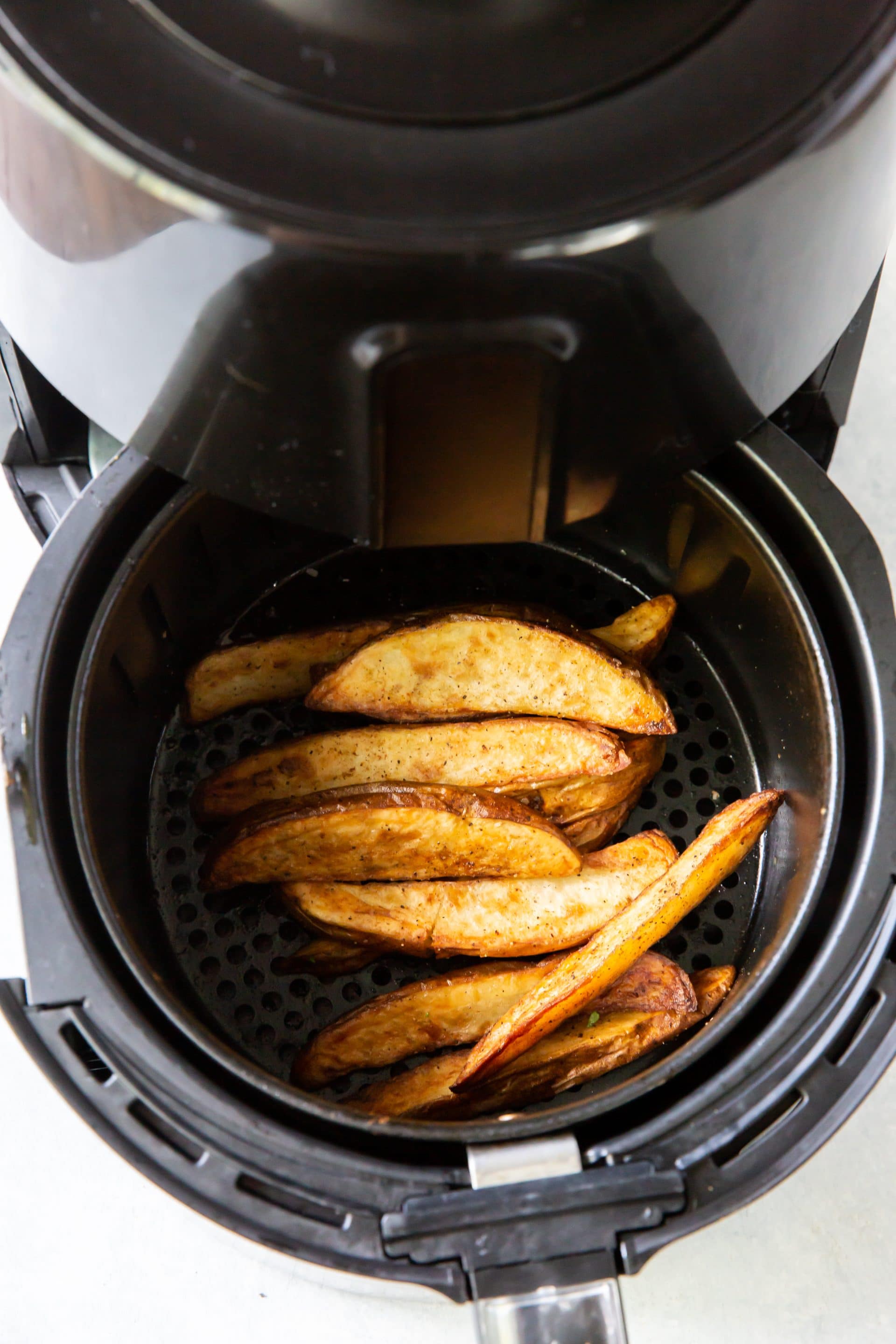 cooked potato wedges in black air fryer