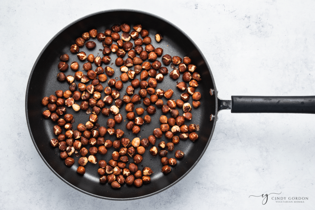 raw hazel nuts in a black skillet