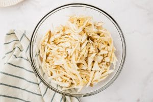 shredded king oyster mushrooms in clear bowl