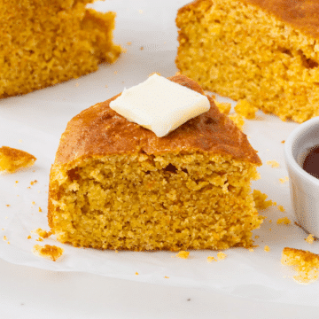 golden brown slices of air fryer cornbread with a square pad of white butter on top