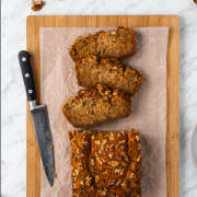 Sliced banana bread on cutting board with a knife.