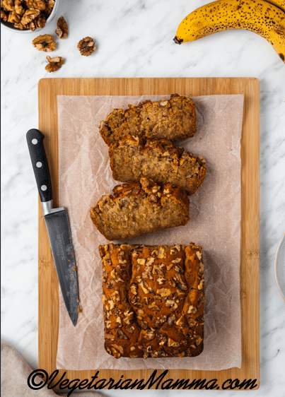 Sliced banana bread on cutting board with a knife.