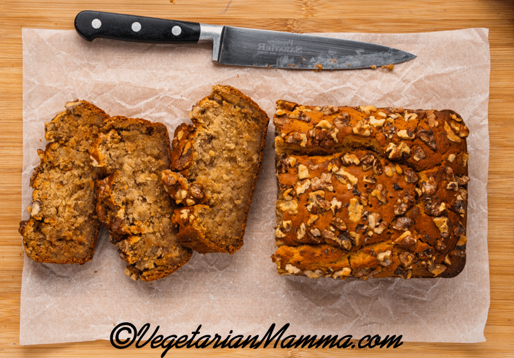 sliced banana bread on a cutting board with a large knife.
