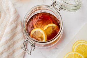 sliced lemons in clear jar with a lot of brown honey