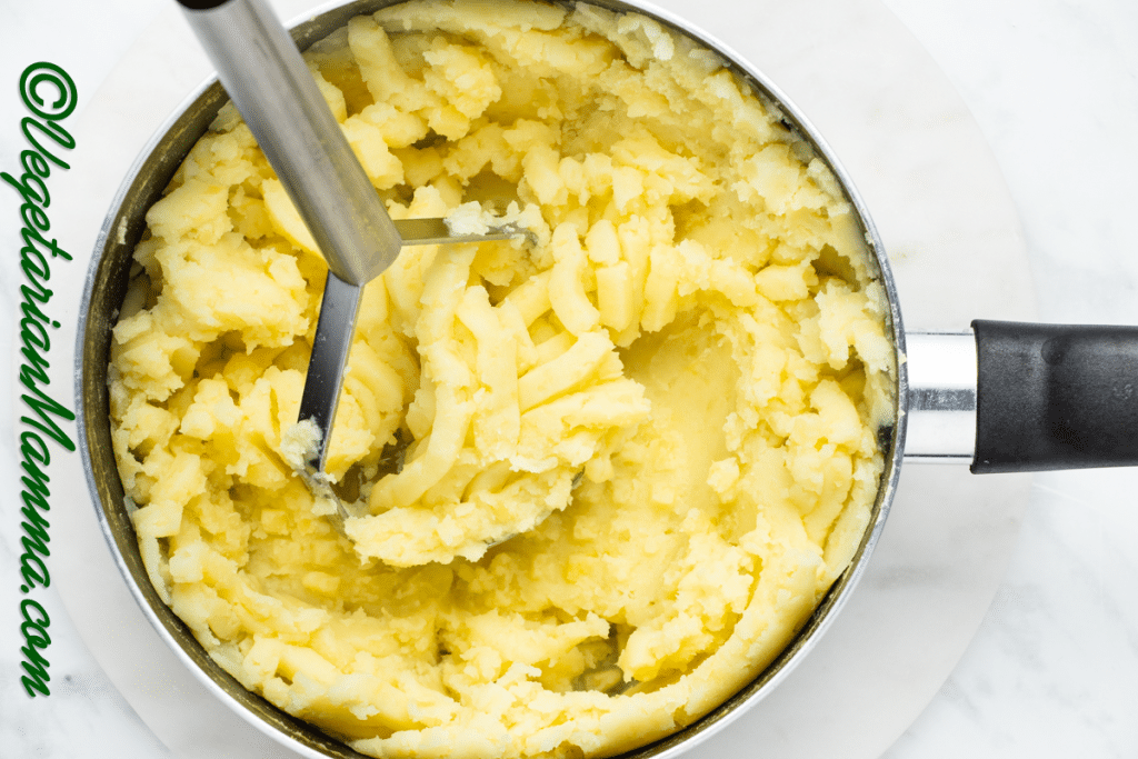 Drained potatoes returned to the pan for appropriate mashing.