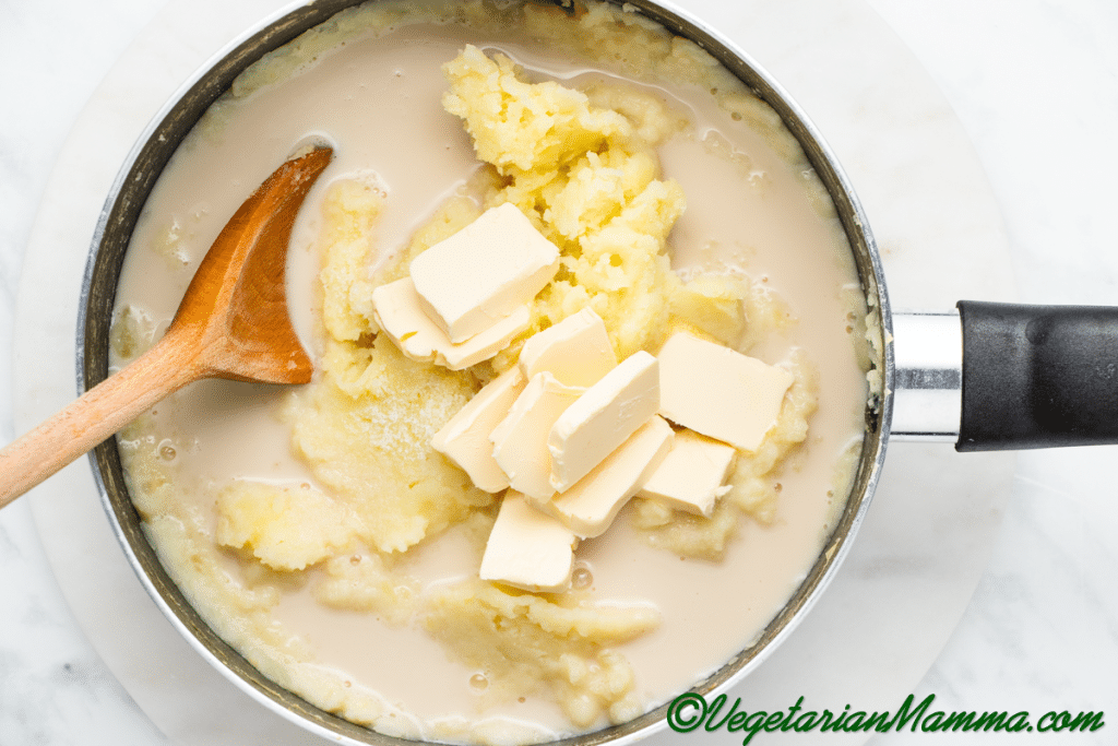 Add almond milk and vegan butter to the pan to make the potatoes fluffy - add the salt and pepper too.